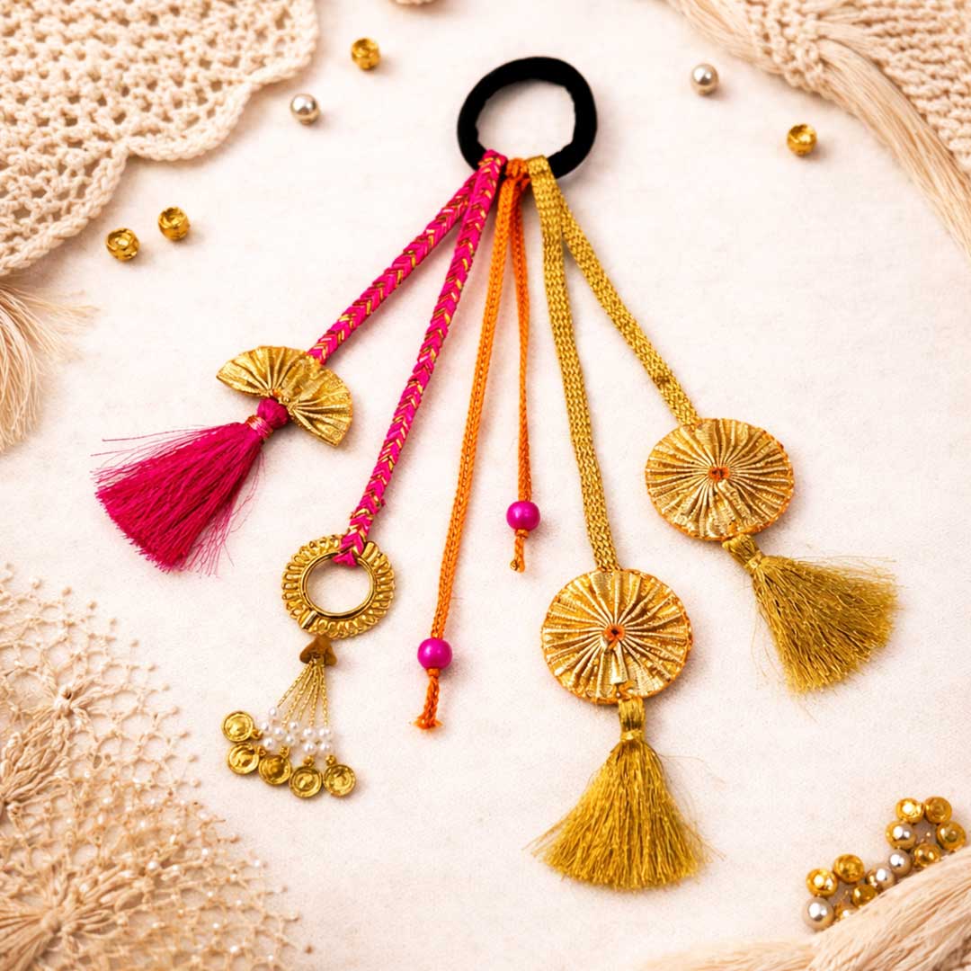 Decorative hair tie with colorful tassels and beads on a textured  Suwasna Pink & Gold Boho Tassel Hair Tie with Fan Charms & Bead Detailing | Stylish Festival, Beach & Casual Hair Accessory Design-5surface